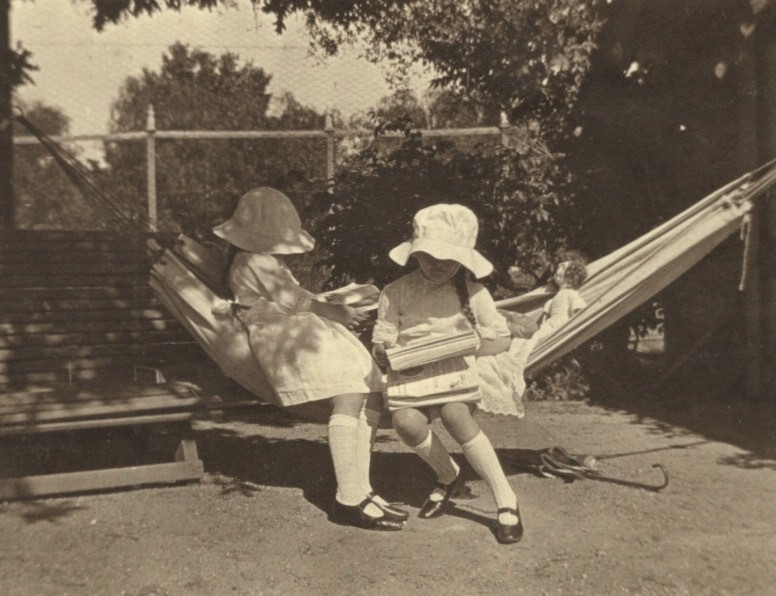 Two grandchildren reading on the hammock