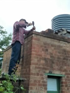 Glenn from Philipson Masonry repointing the parapet brickwork on the toilets